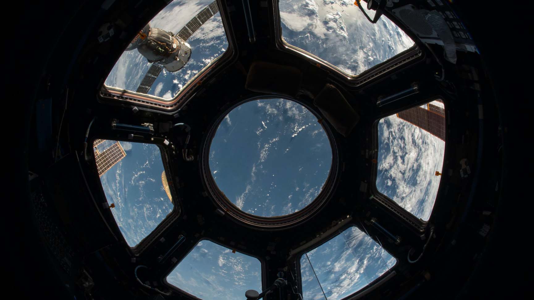 Photo of view from inside spacecraft space wheels looking out at earth's surface