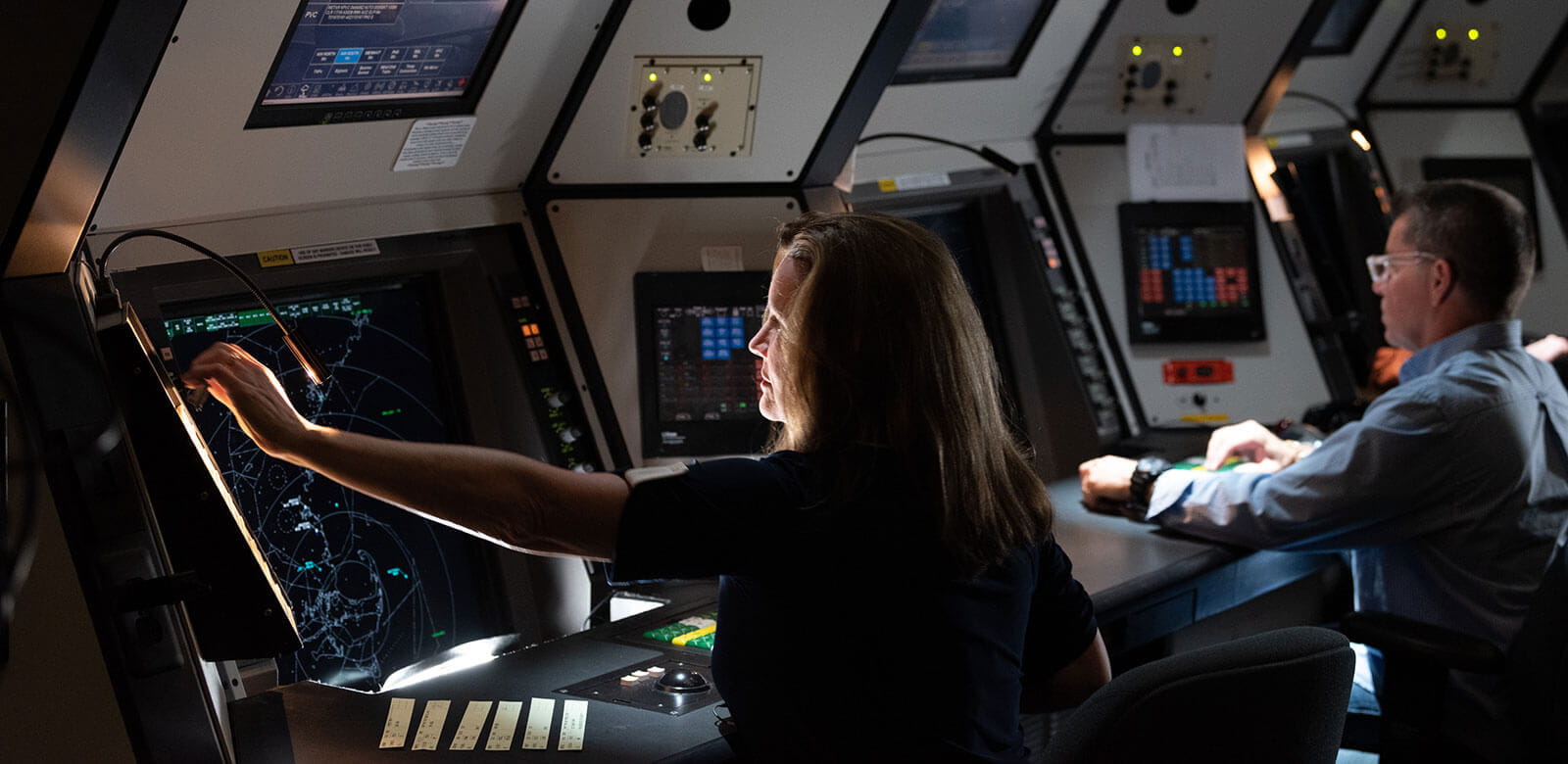 People sitting in front of air traffic control screens.