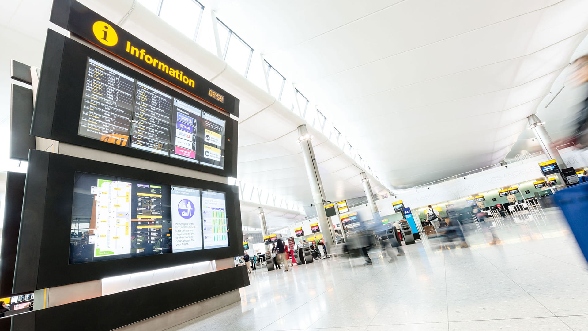 Airport terminal with check in counters and digital information displays