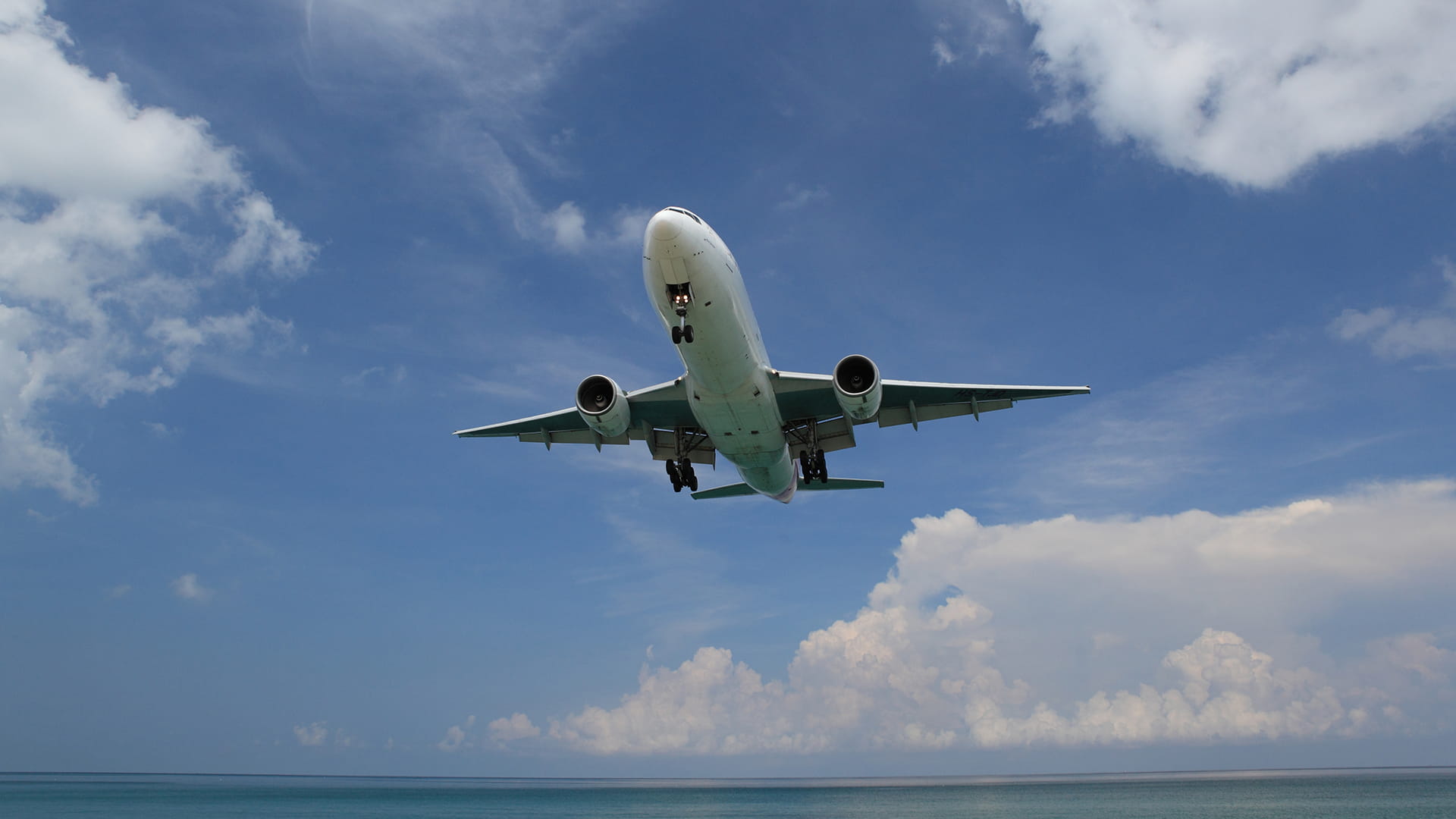 airplane flying in the blue sky white clouds