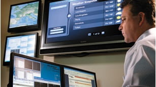 man working infront of computer monitors