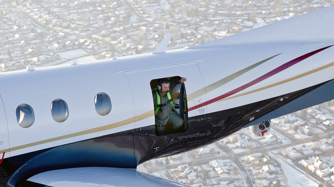 Man standing in customizable doorway while aircraft is flying over a city