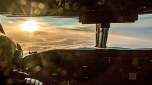 a pilot with an oxygen mask on in the cockpit