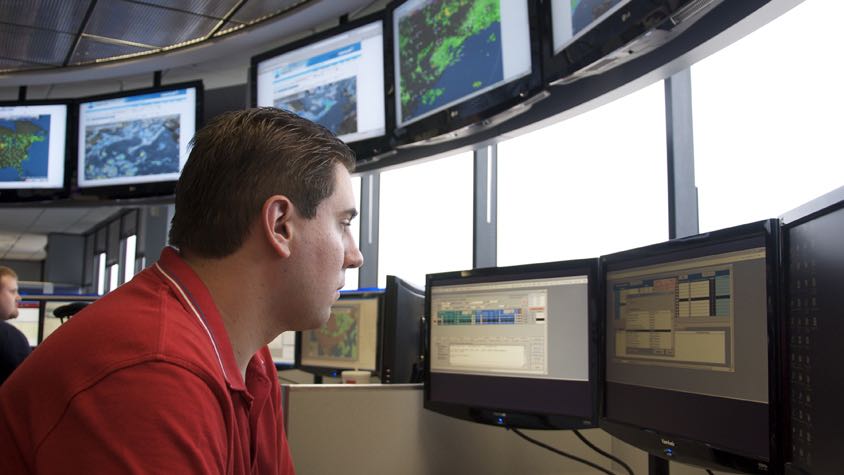 man working in front of computer monitors