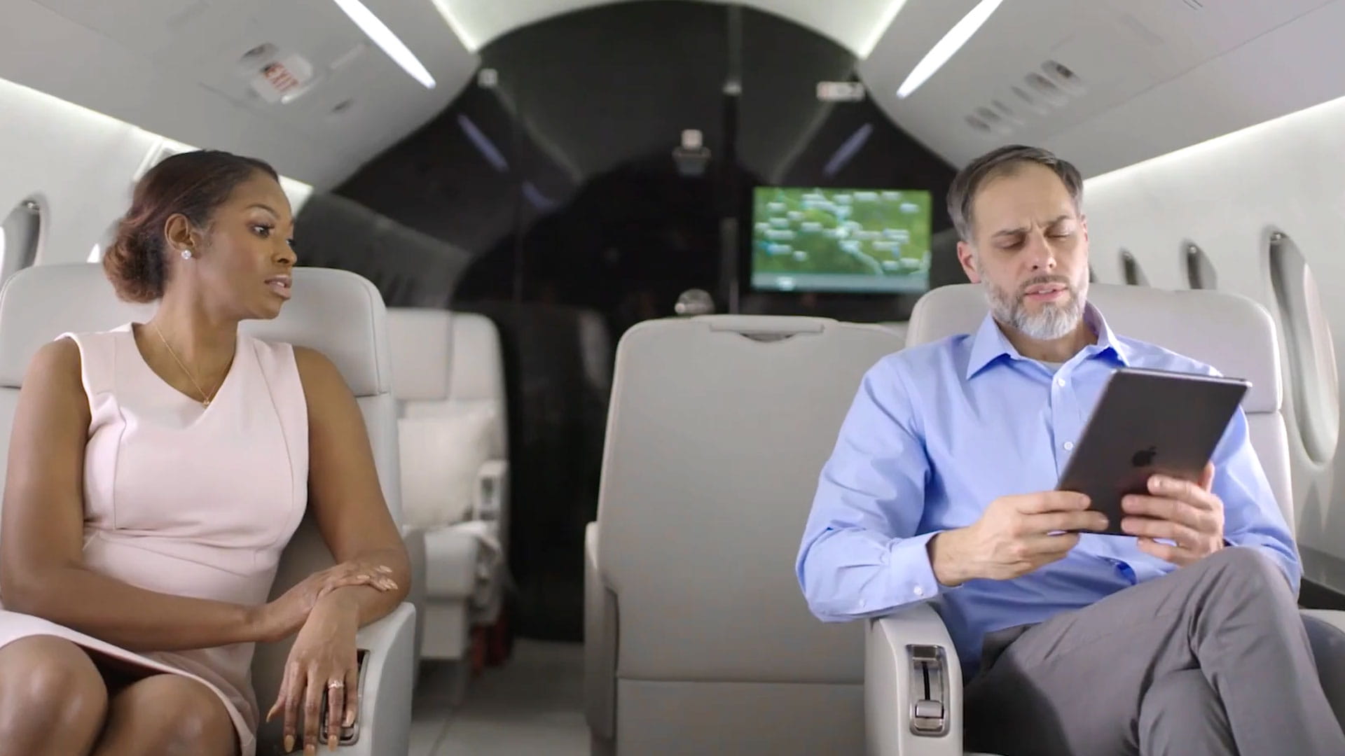 A man and woman in a business aircraft cabin