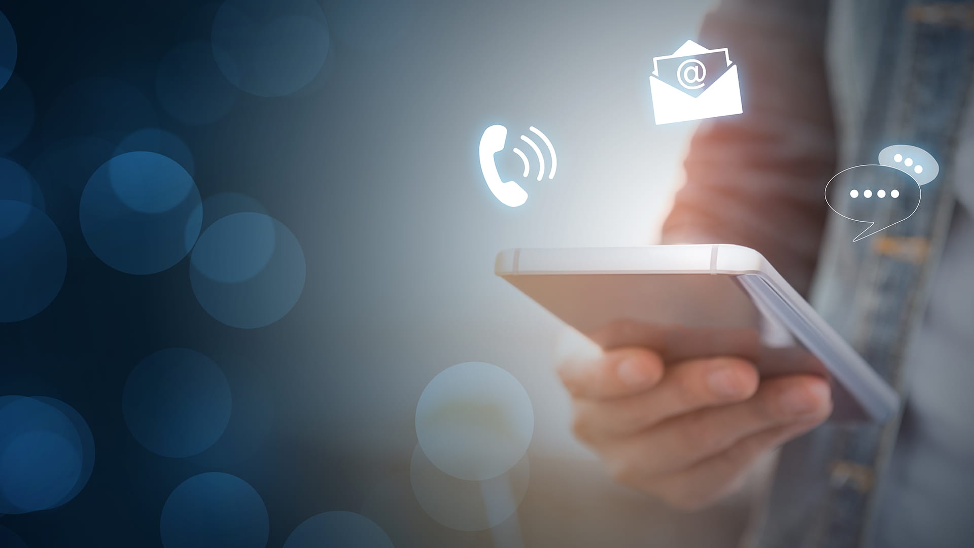 Hand of a businessman holding a mobile smartphone with icons representing call, text and email
