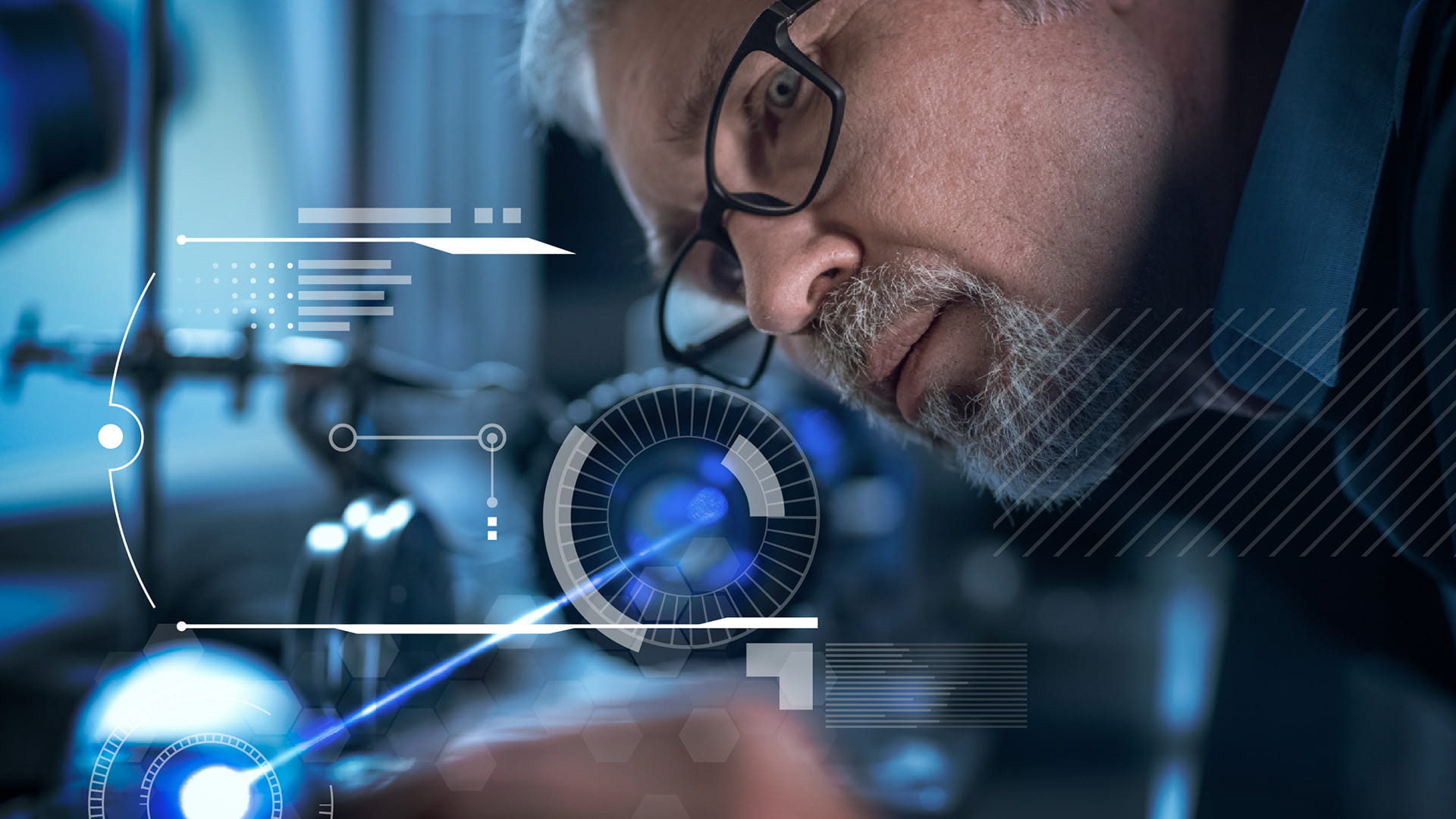 Engineer in glasses working with high precision laser equipment, using lenses and testing optics for accuracy required electronics