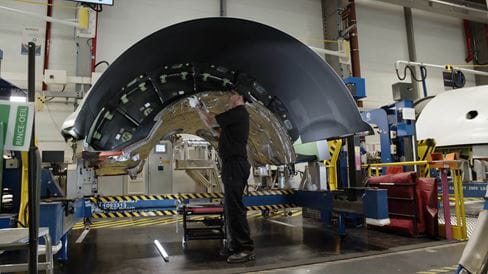 a maintenance technician working on part of a nacelle in the shop