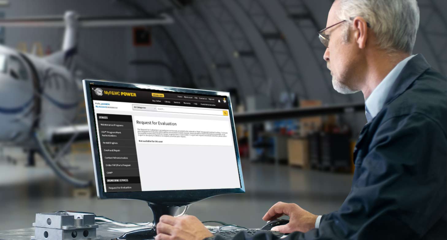 A man sitting at a desk viewing a computer monitor