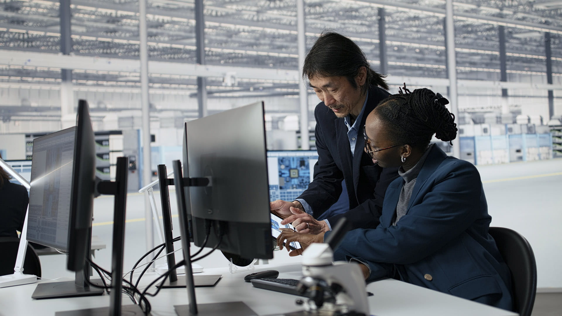 two people looking at a tablet in an office setting