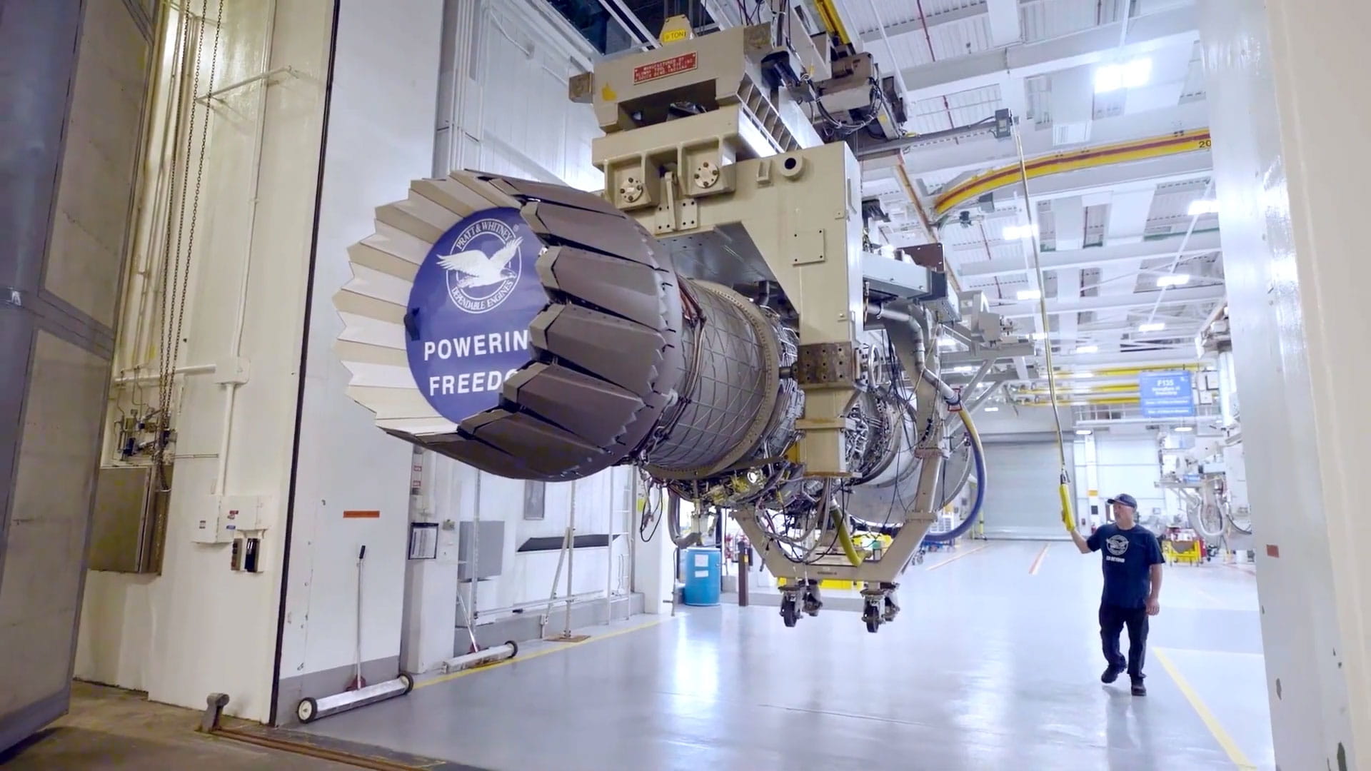 A man stands next to an RTX Pratt & Whitney F135 engine