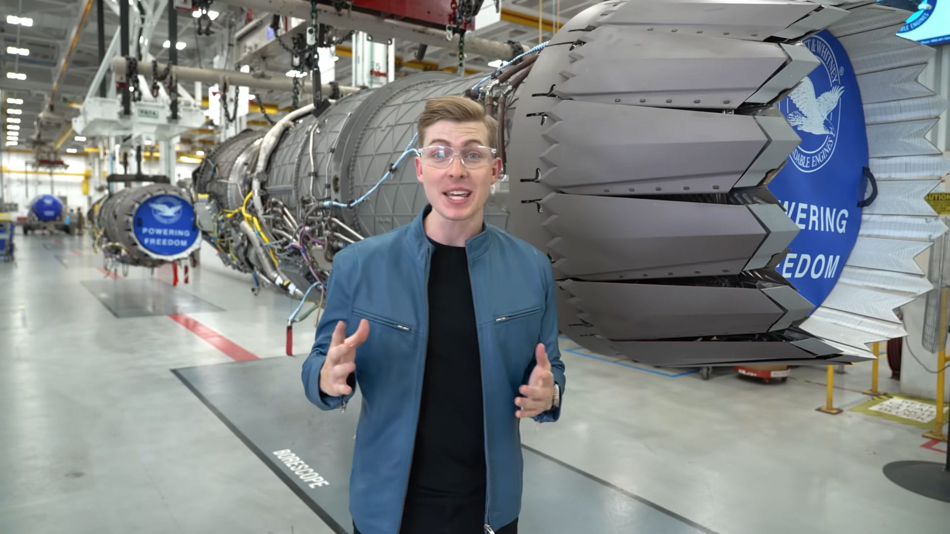 Sam Eckholm stands in front of an RTX Pratt & Whitney F135 engine
