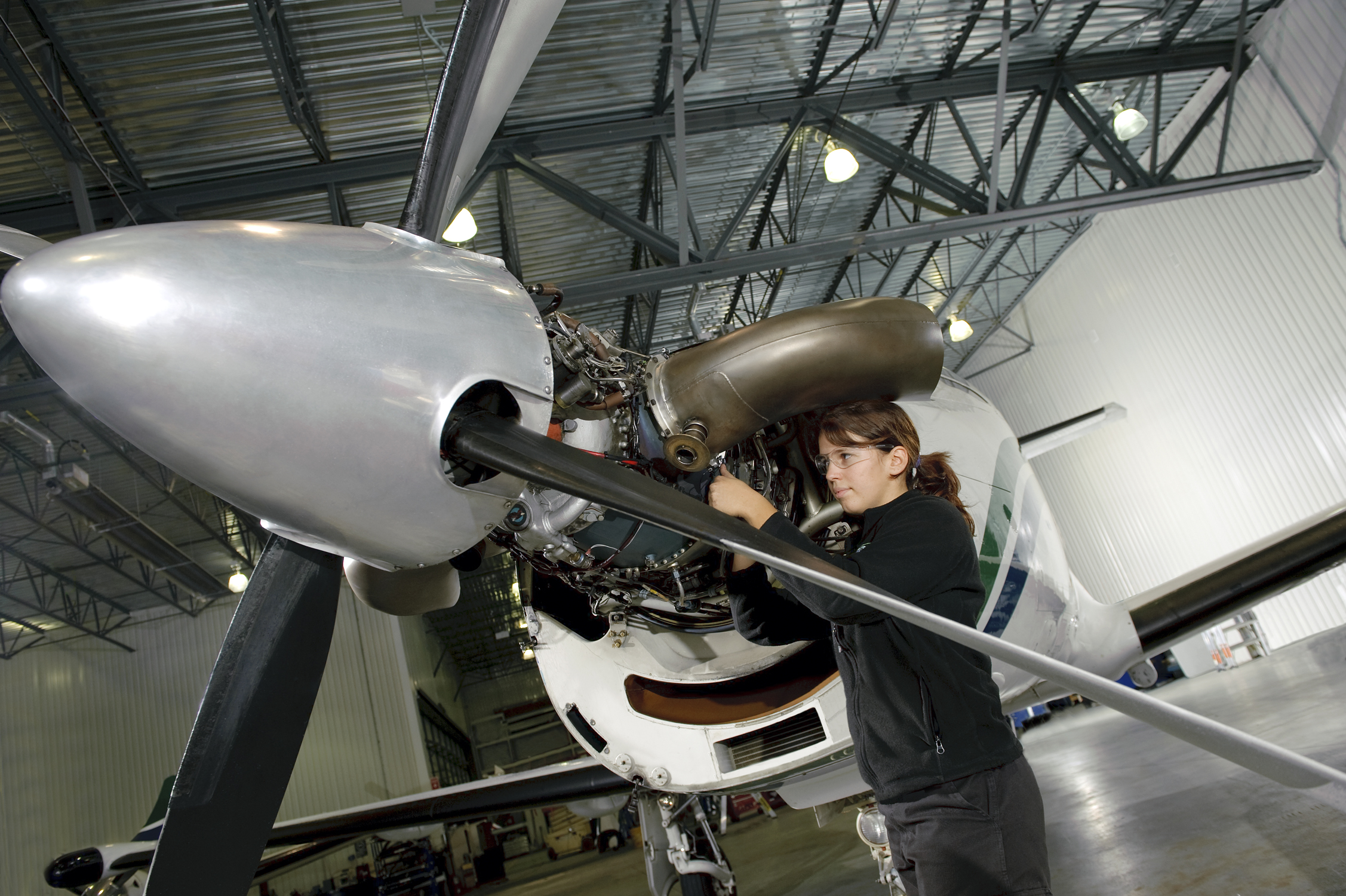A mechanic working on the propeller of an airplane