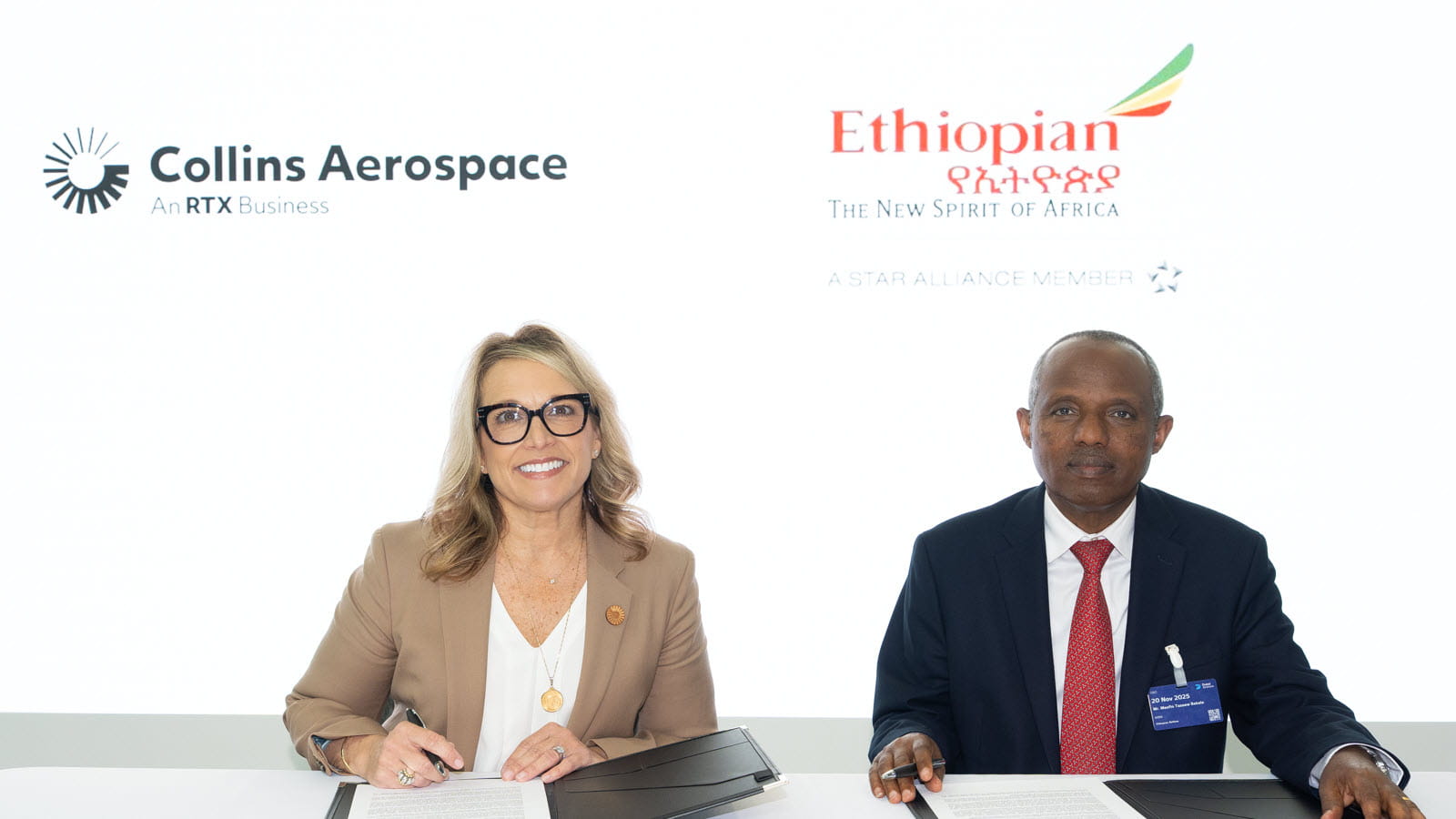 A man and woman pose for a picture during a signing ceremony between Ethiopian Airlines and Collins Aerospace
