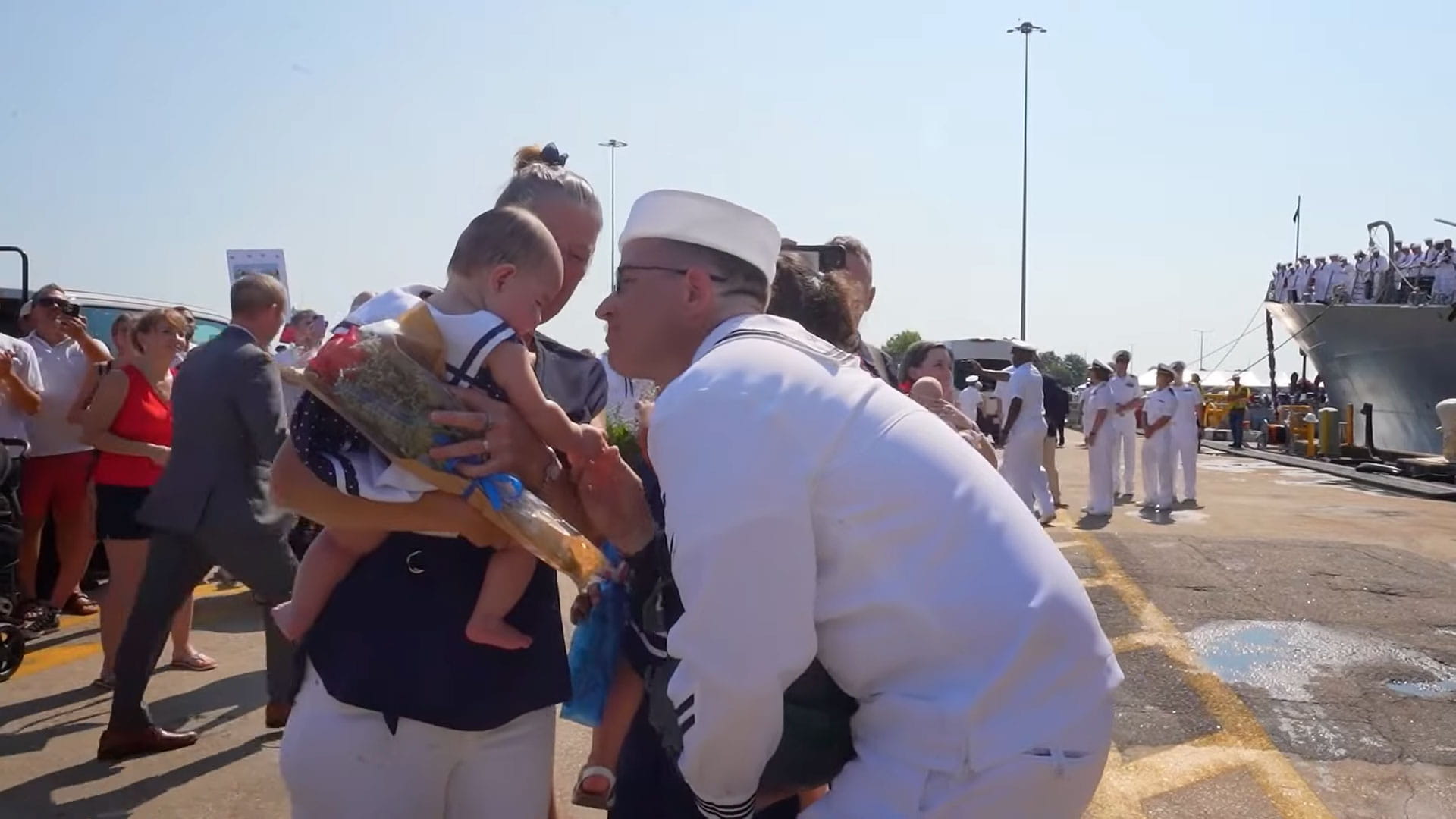 A sailor greets his wife and child