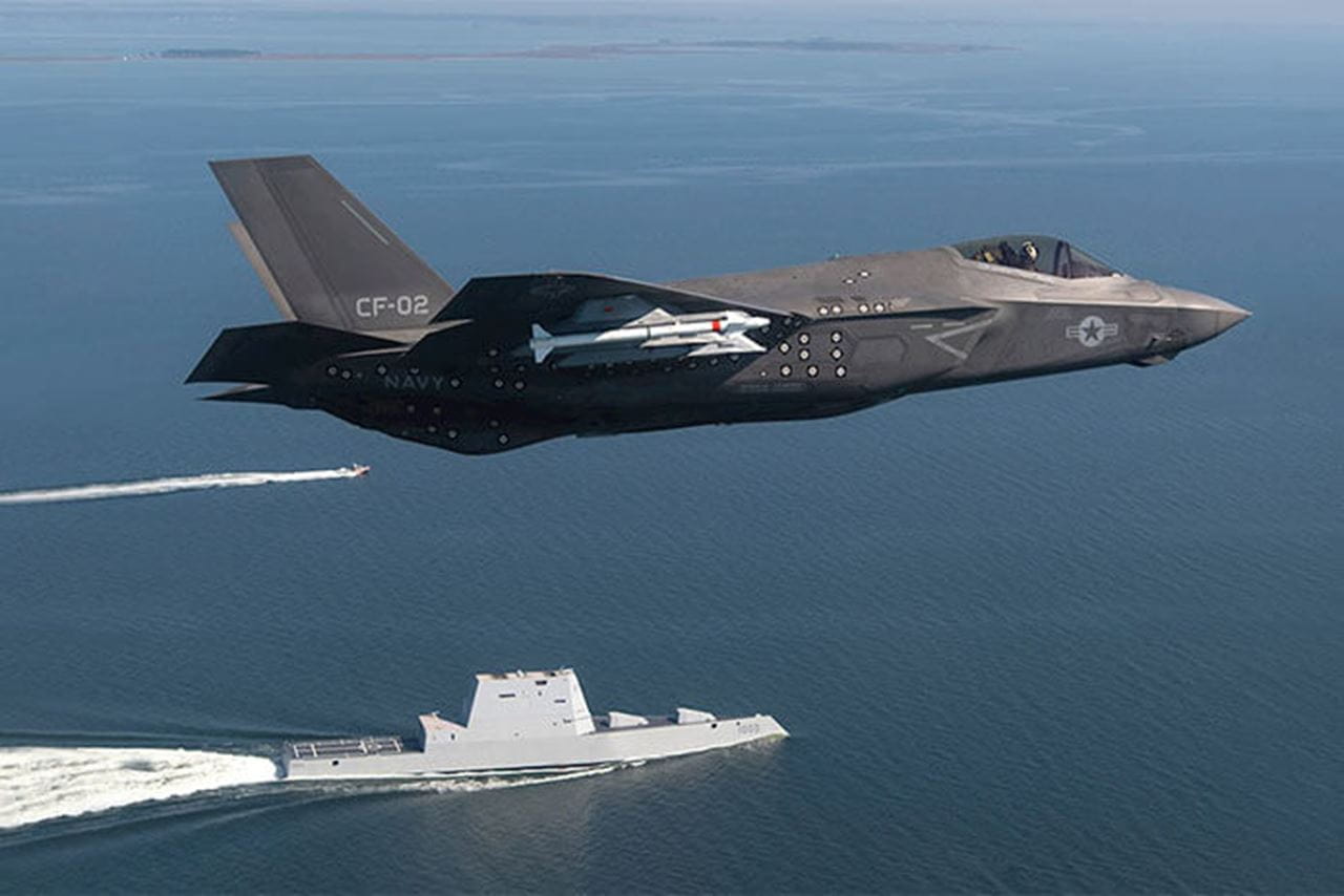 An F-35 flies over the ocean.