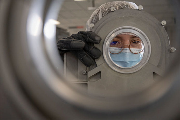 A Raytheon Intelligence & Space technician places pieces of the outer shell of a Multi-Spectral Targeting System into a small oven during the assembly process in the new AIM Center.