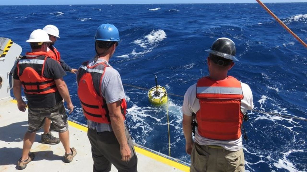 Three people work on a boat during a CDMaST maritime demo.