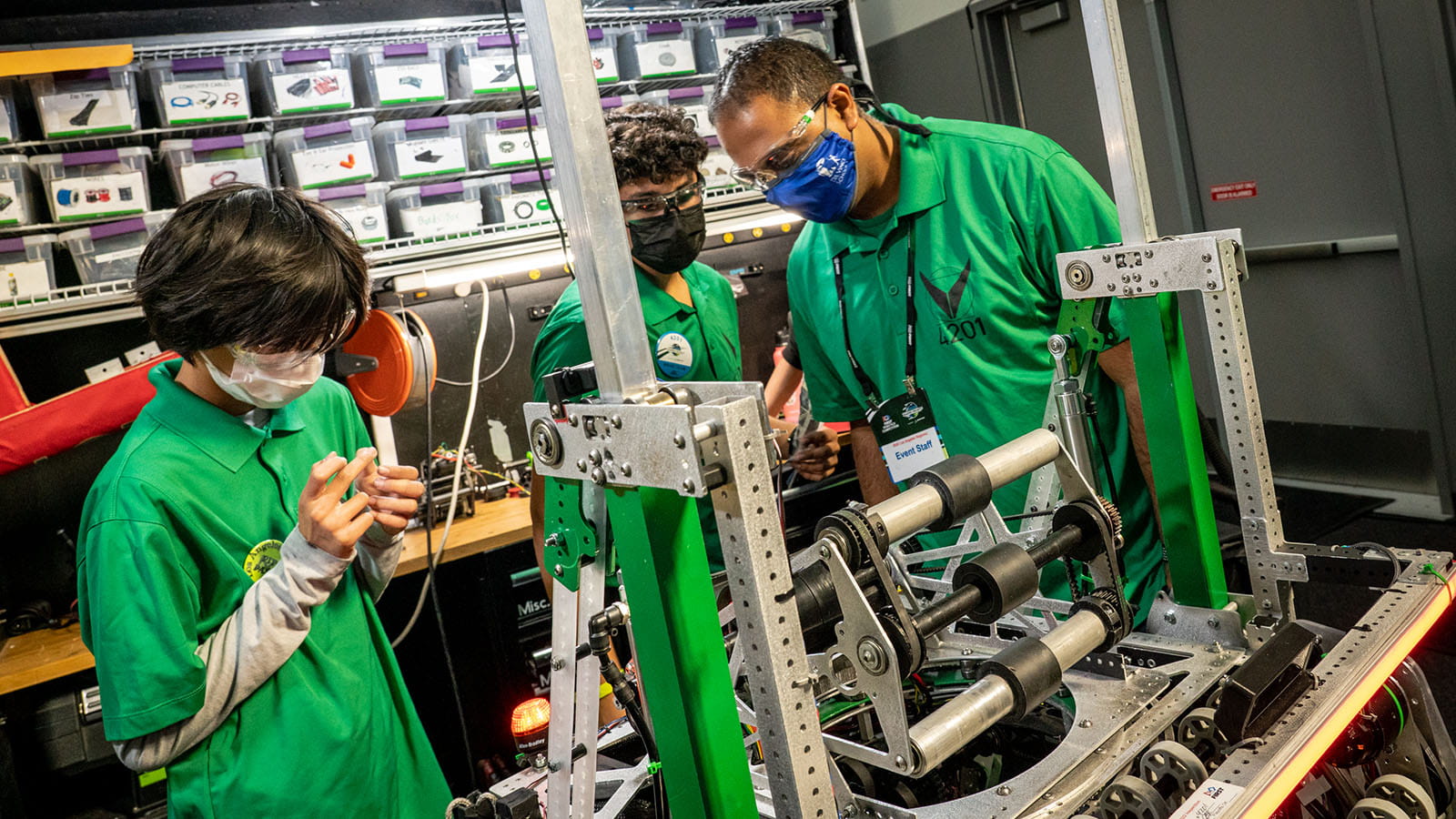 Fuzz Zubair inspects The Vitruvian Bots' robot while students prepare for the next match at the FIRST Robotics 2022 Los Angeles Regional.