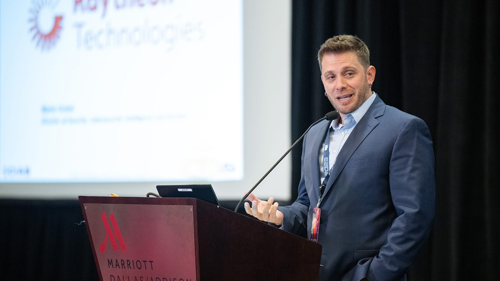 man in suit on stage talking