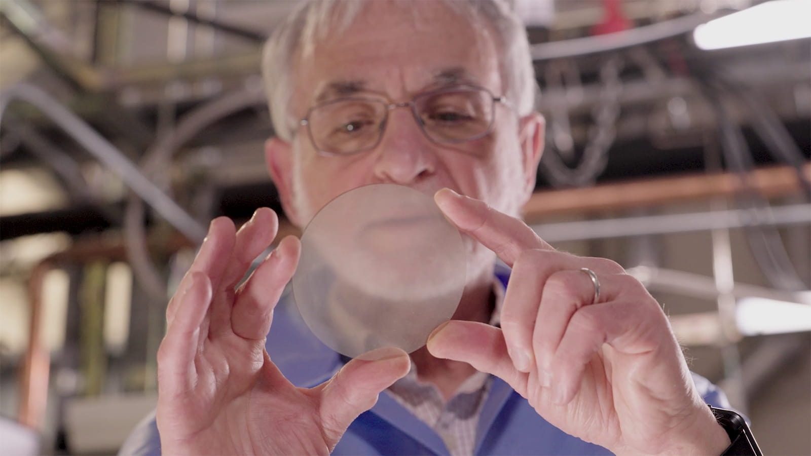 A man inspecting a semiconductor wafer