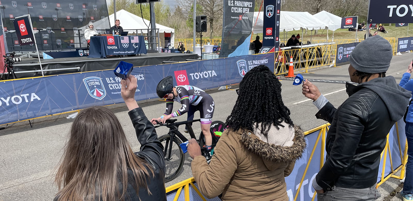 Spectators cheer from the sidelines as an athlete crosses the finish line.