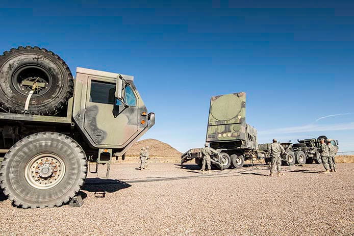 Soldiers stand next to the Patriot air and missile defense radar.