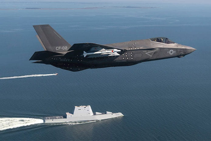 An F-35 flies over the ocean.