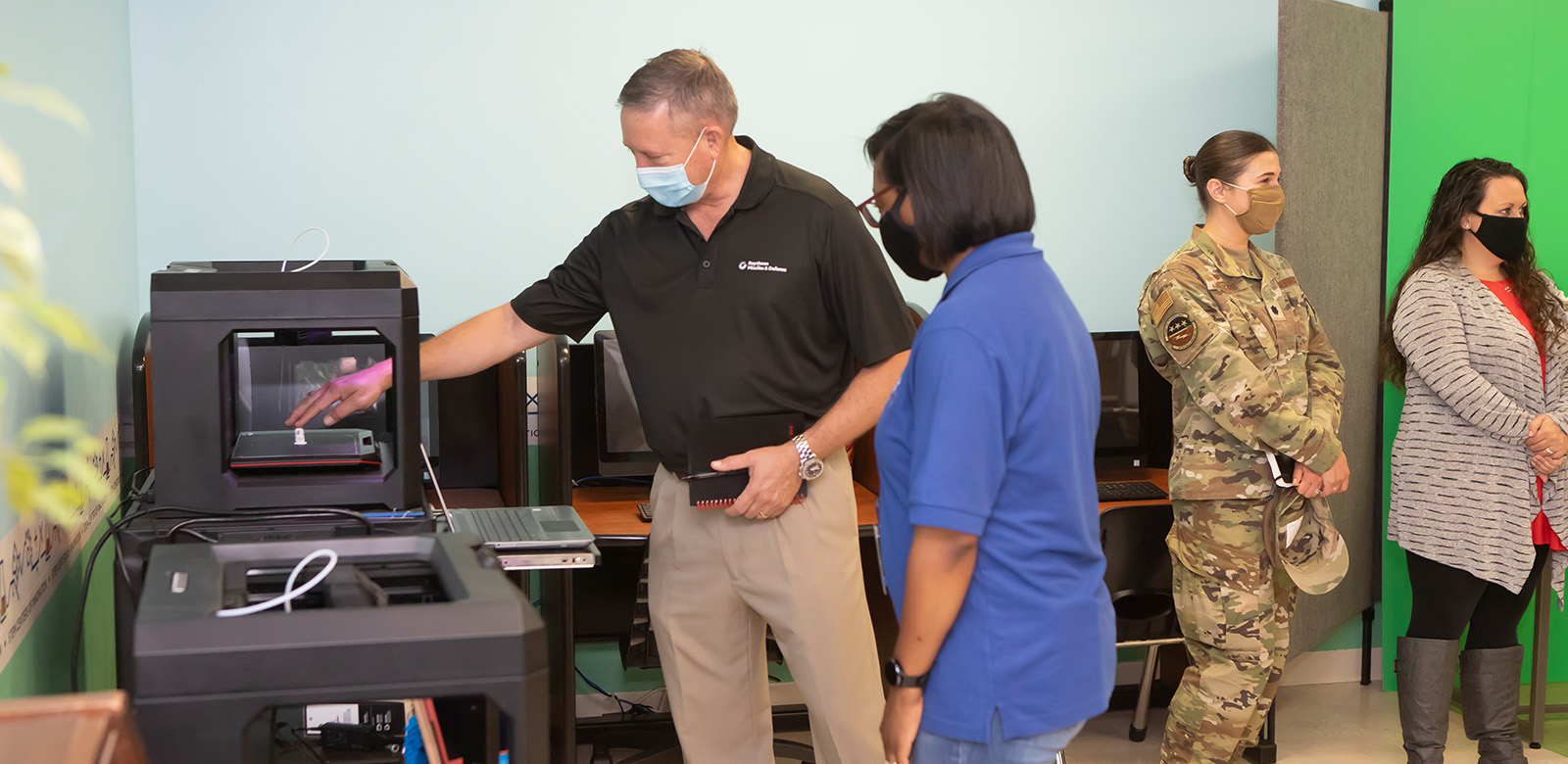 Jon Norman, who leads customer requirements and capabilities for Air Power at Raytheon Missiles & Defense, examines a 3D printer at the Eglin Air Force Base Youth Center in Florida. The company visited the center and donated supplies to support its gradual reopening amid the coronavirus pandemic.