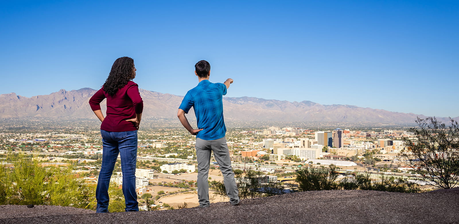 While hiking, two people take in a view of the Tucson valley.