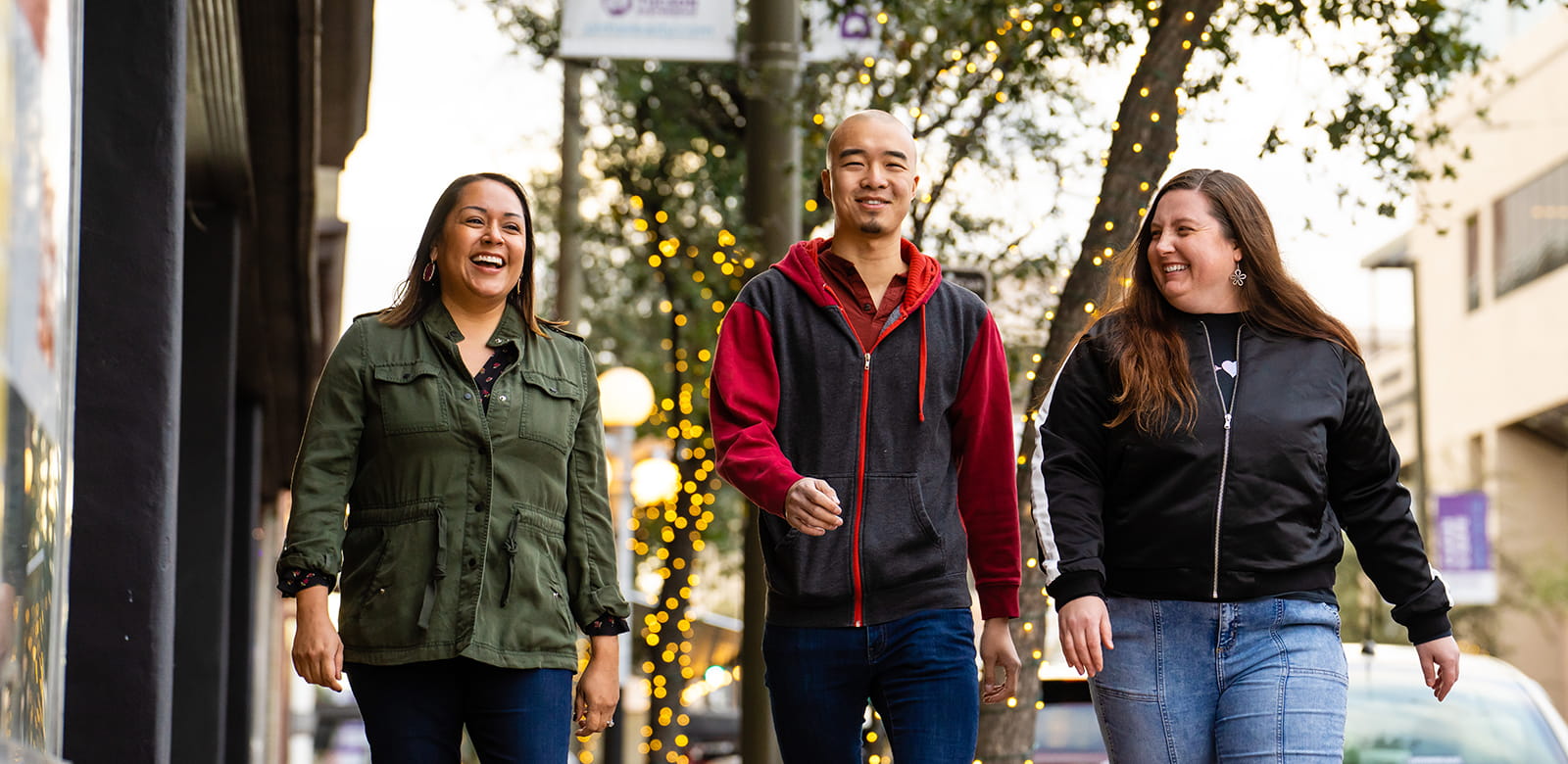 Three people walk together through downtown Tucson