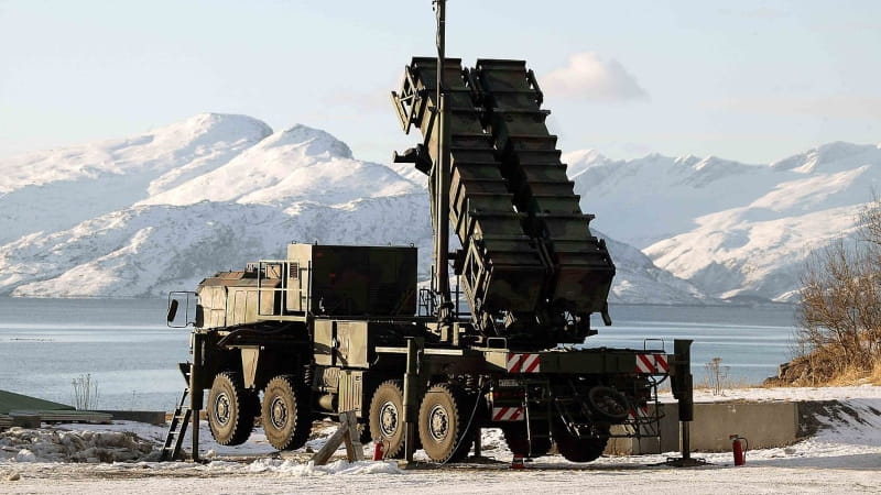 The Patriot missile launcher stationed in front of snow-covered mountains. 