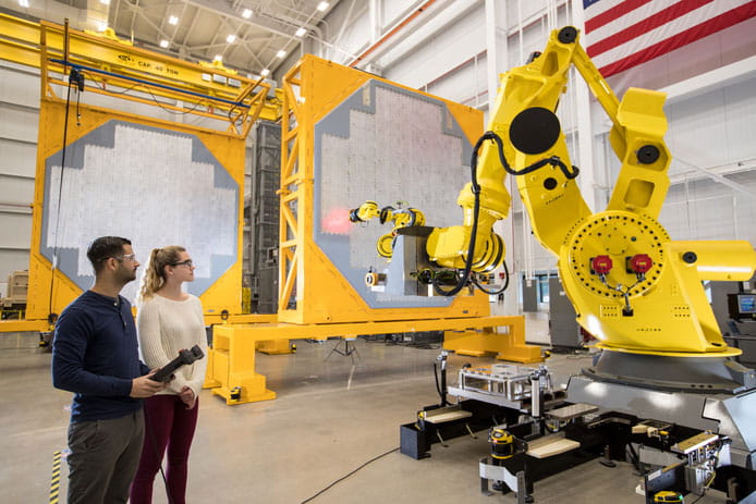 Robotic arm assembling face of a radar.