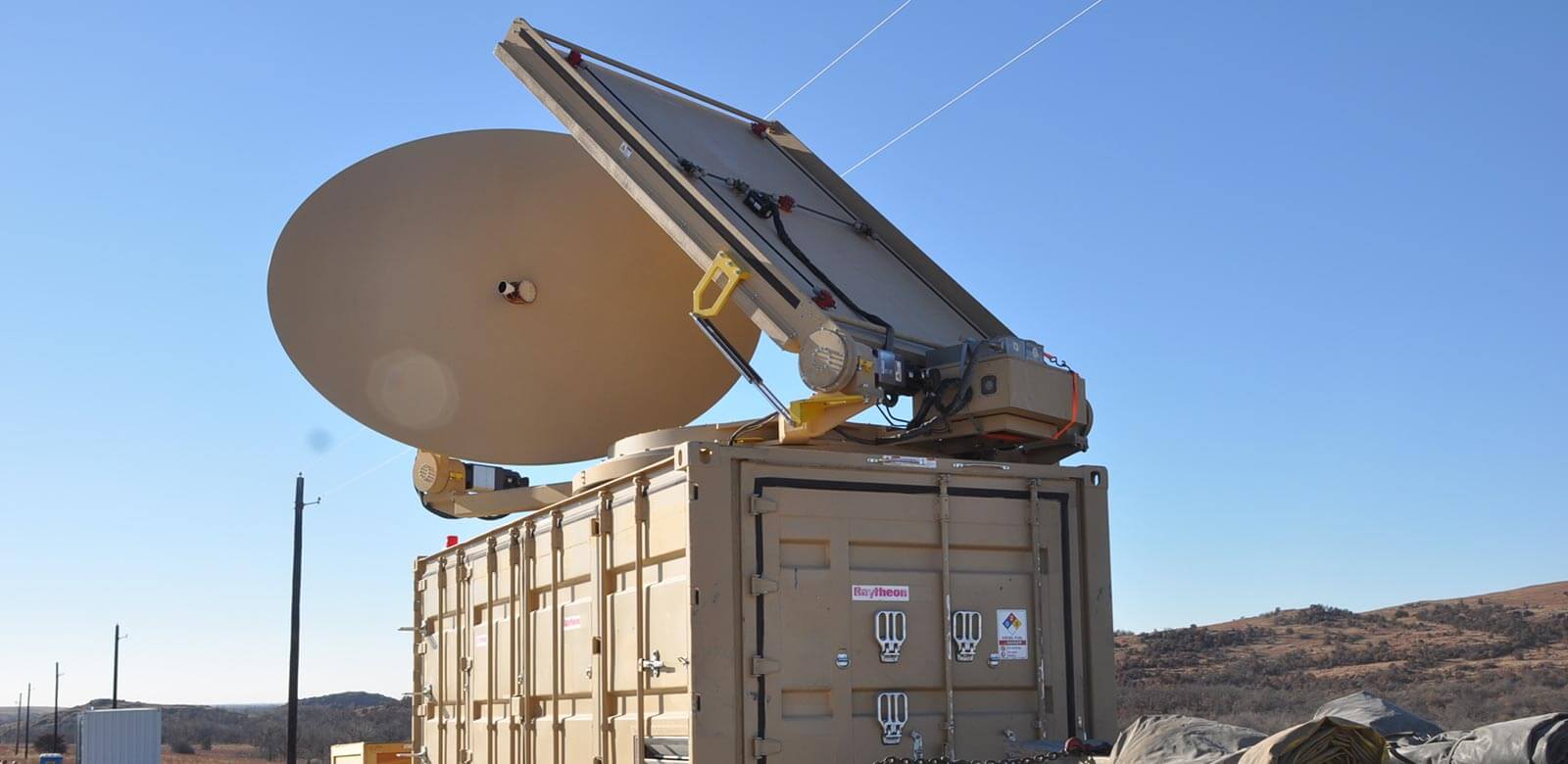 Radar on the top of a container being towed by a flatbed truck