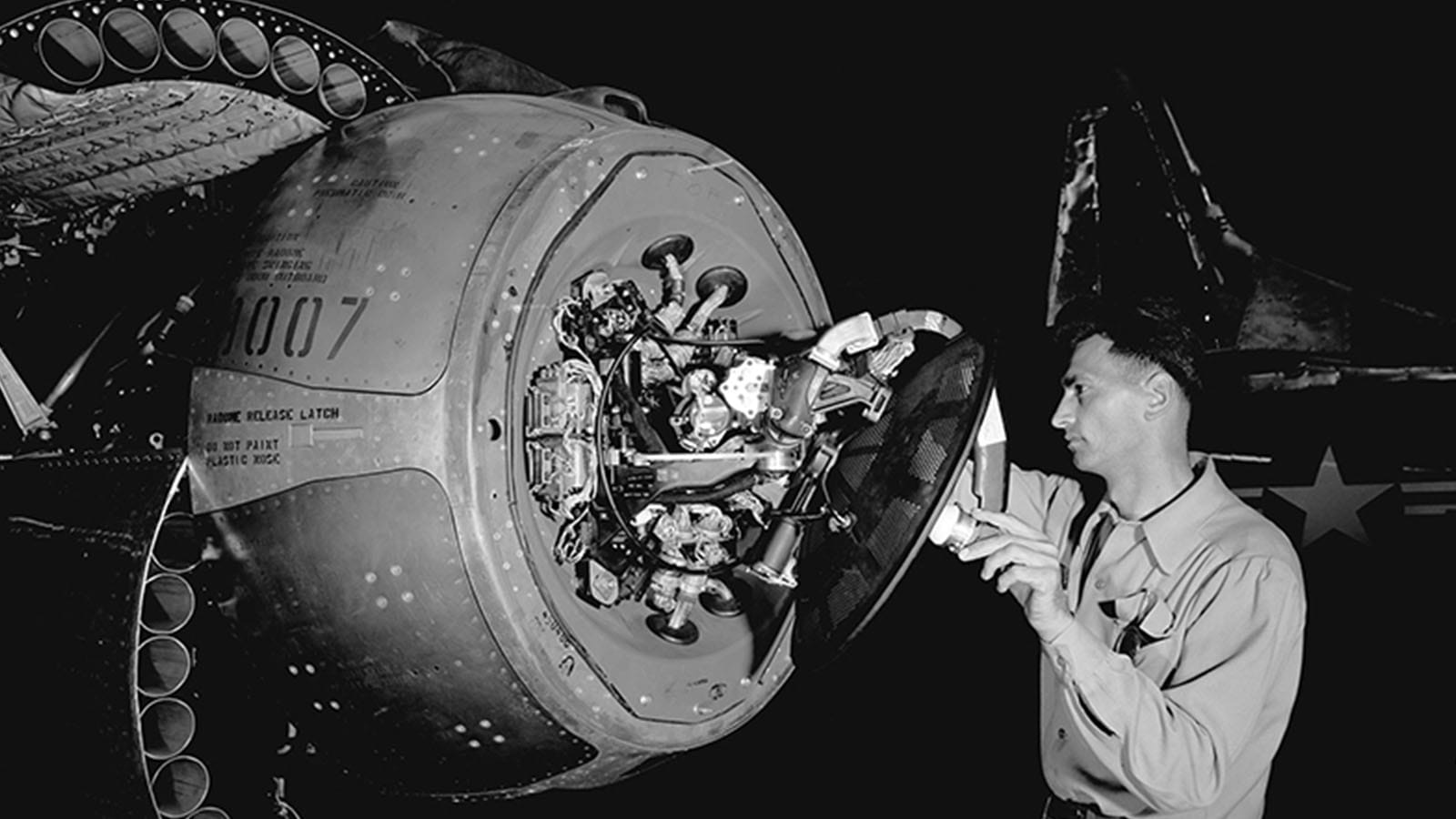 An APG-40 radar antenna is inspected during routine maintenance on board a Lockheed F-94C Starfire Interceptor.