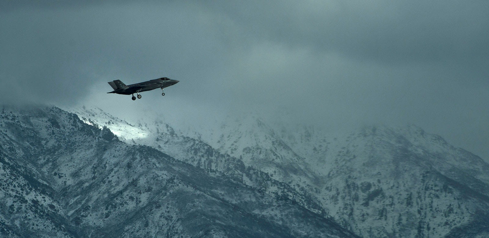 F-35 in flight over mountain range