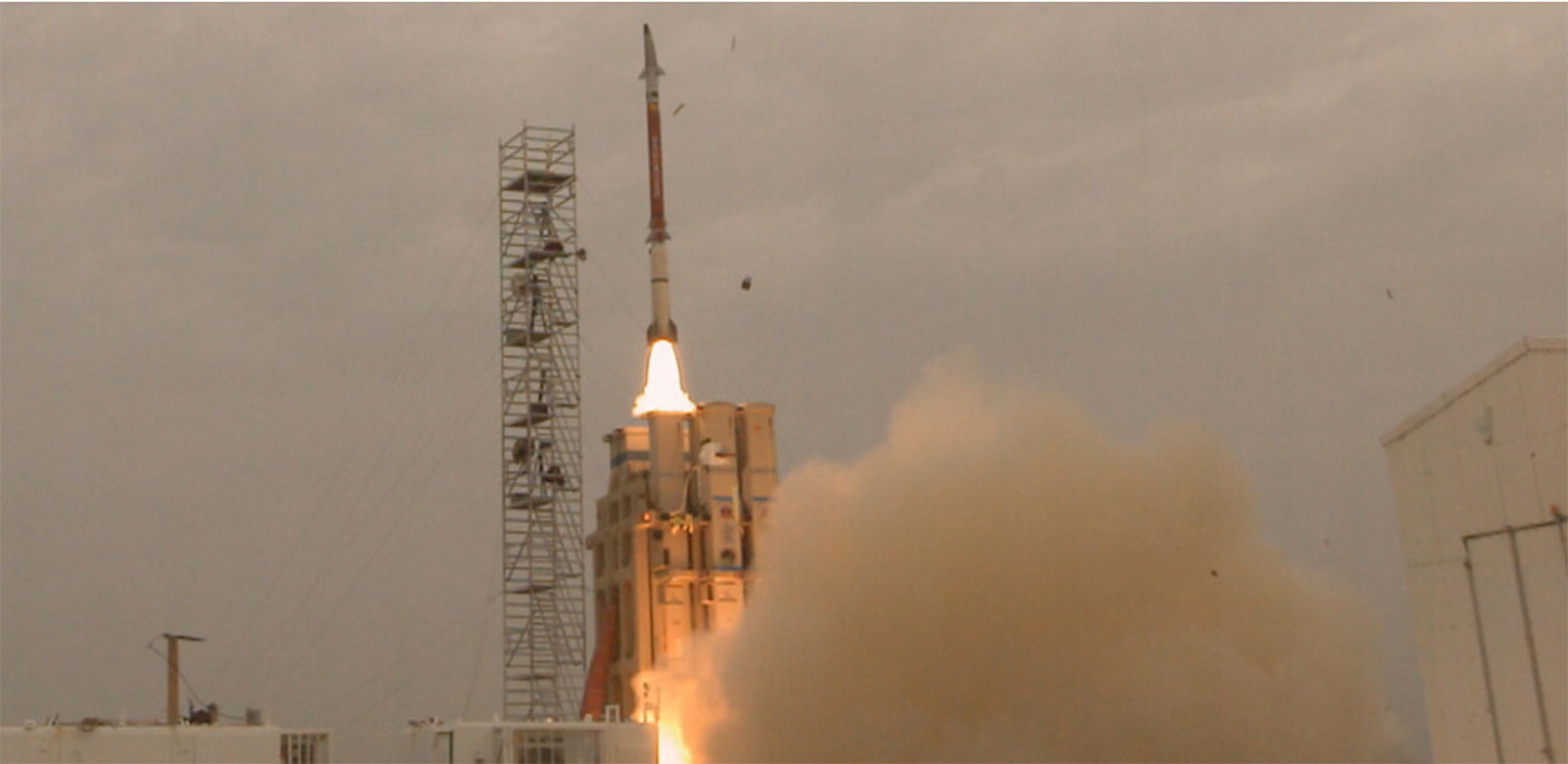 Missile being launched vertically from a launch pad.