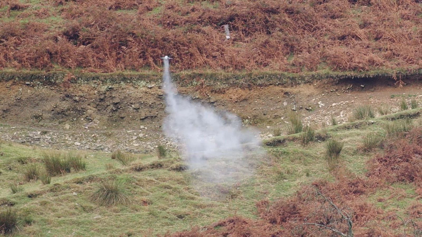 A drone being launched over a hilly region