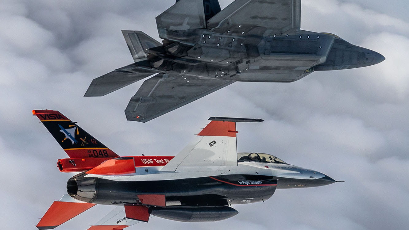 A fighter jet and aircraft test jet fly in close proximity