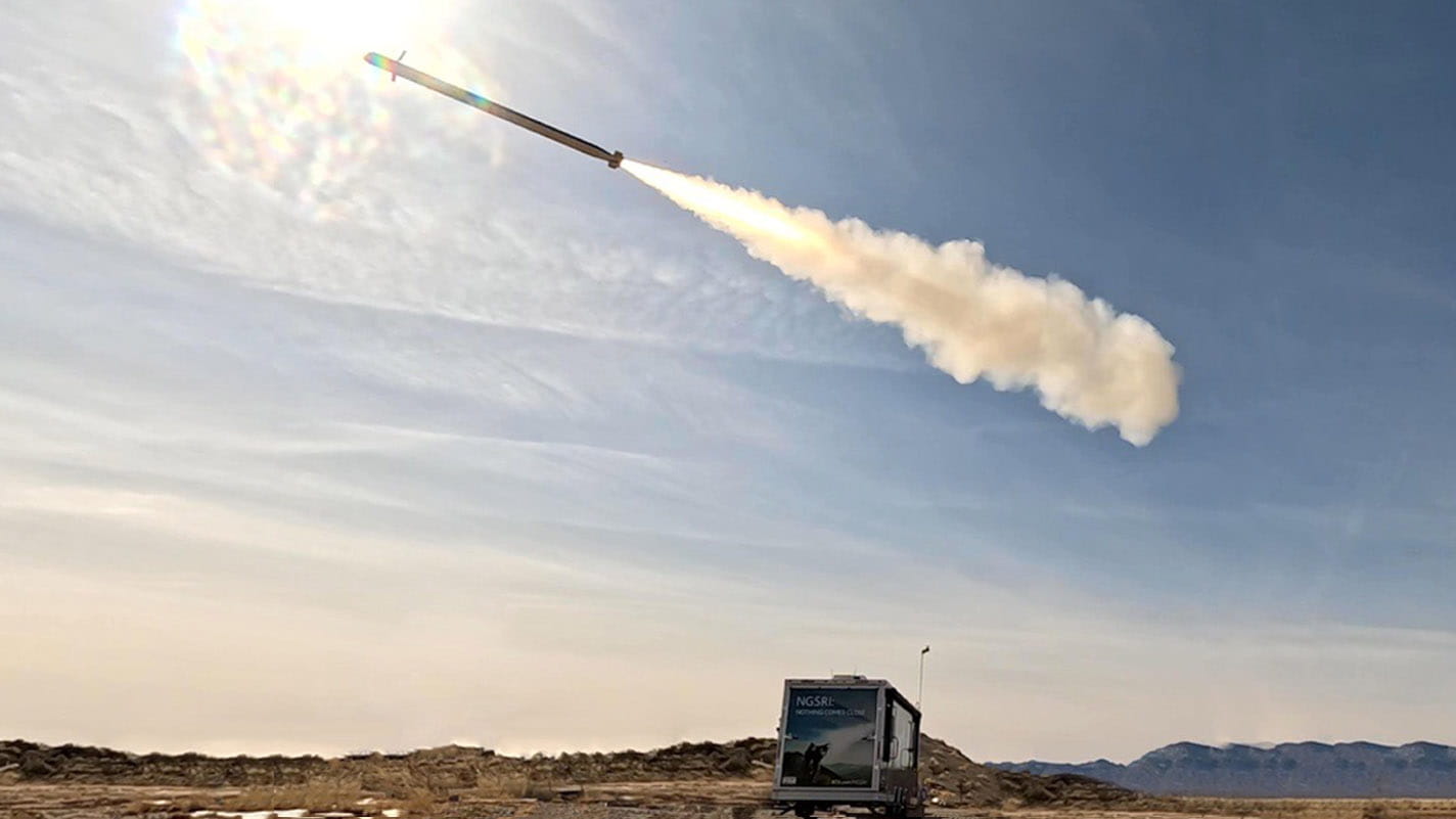 A short range intercetor missile flies over a truck in a remote area