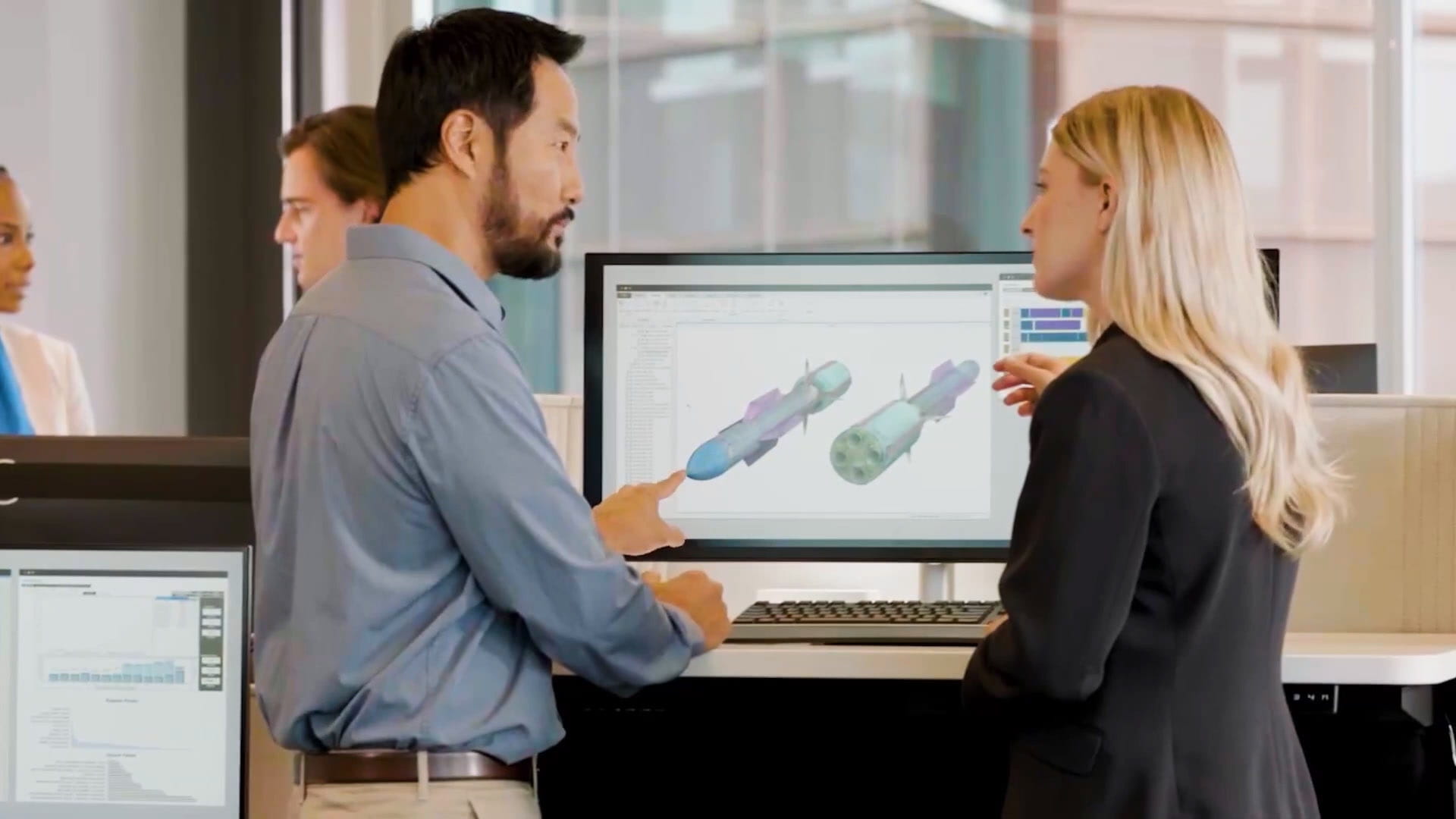 two people talking in front of a computer screen