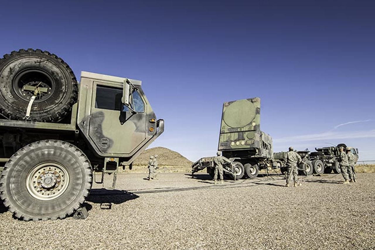 Soldiers stand next to the Patriot air and missile defense radar.